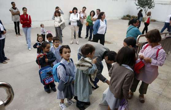 Varios niños esperan el momento de entrar en clase. 
